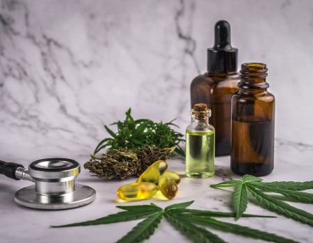 Assorted cannabis products, pills and cbd oil over medical prescription sheet - medical marijuana concept.